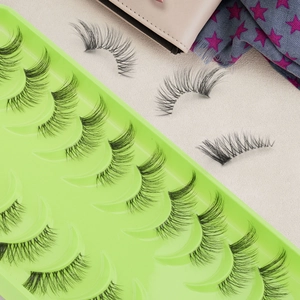 Detail of 10 pairs natural cross false eyelashes set in green tray with pink accessories