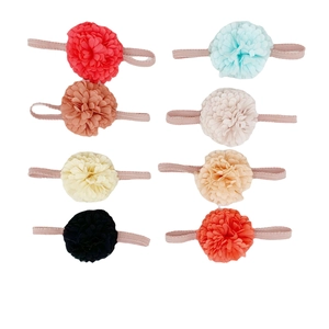 Detailed flat lay of 8 colorful fabric flower elastic nylon headbands for babies