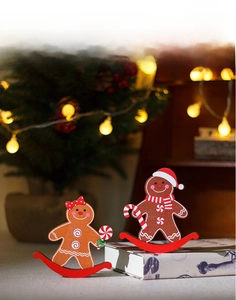Detailed view of two wooden gingerbread tumblers with cozy Christmas tree and light background