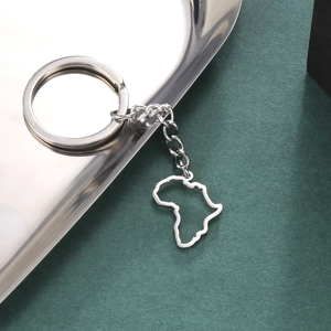 Polished silver stainless steel Africa map keychain pendant on reflective tray