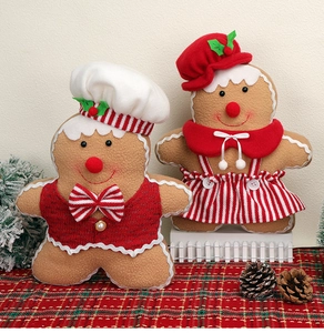 Detailed view of plush gingerbread man and woman dolls in festive Christmas costumes