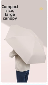 Detail view of large beige sun umbrella canopy providing full upper body coverage