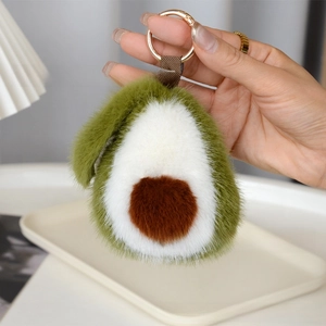 Détail d'un porte-clés avocat en peluche douce avec anneau doré et texture soyeuse
