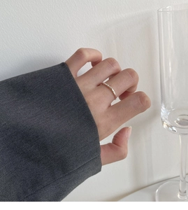 Anello aperto in argento martellato irregolare da donna indossato sul dito in primo piano