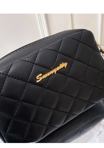 Detailed close-up of a black quilted leather handbag with gold Sunnypetit metal logo