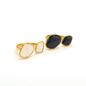 Detailed shot of irregular geometric gold rings featuring black and white shell inlays