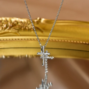 Close-up of a double layered silver cross necklace with polished and zircon stones details