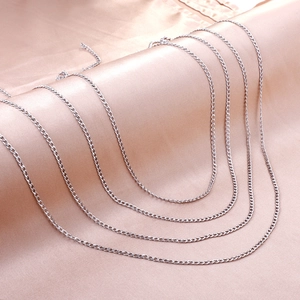 Vielseitige 2,3mm Edelstahl-Panzerketten auf elegantem rosa Seidenstoff präsentiert