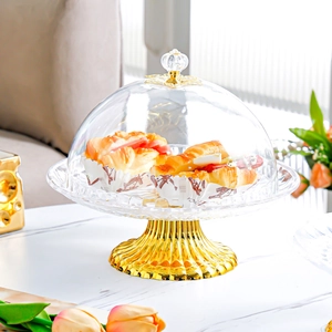Detail of a European gold-finished cake stand with clear dome lid for dessert display
