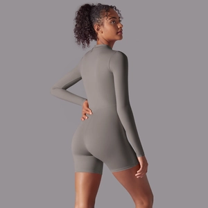 Detail of grey athletic long sleeve playsuit showing slim fit cut and elastic fabric texture