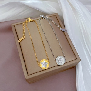 Detail of star-shaped charms with pavé crystals on gold and silver stainless steel chains
