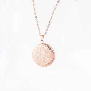 Vue détaillée d'un médaillon rond en or rose avec gravure de motifs floraux complexes