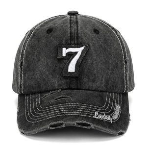Detail view of the washed black baseball cap with distressed holes and number 7 embroidery