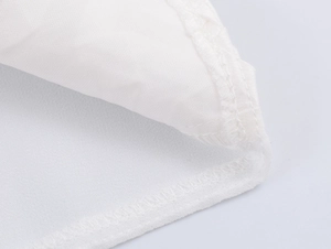Gros plan sur la texture du satin et les coutures précises de cette chemise blanche