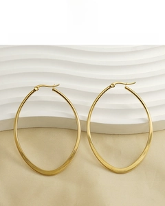 Detail of large oval 18K gold plated hoop earrings showing smooth polished steel texture