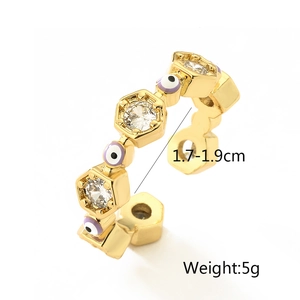Dettaglio dell'anello dorato con occhio greco, zirconi e design aperto regolabile
