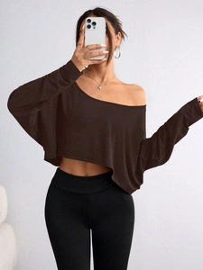Detail of dark brown off-shoulder crop top with long sleeves and soft knit texture