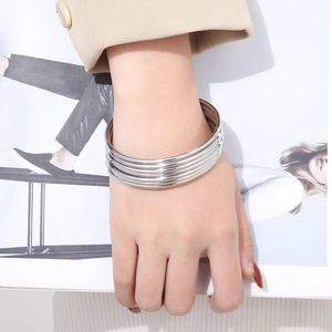 Detailed view of 3mm silver stainless steel stackable bangles on a model's wrist