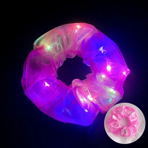 Detail of pink mesh LED scrunchie showing luminous effect in dark and normal daylight view