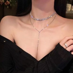 Detail of silver layered choker and Y-shaped zircon necklace set on a female model