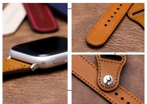 Detail view of brown leather watch band with precise stitching and magnetic metal buckle