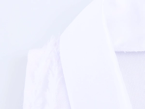Close-up of elegant white sleeveless dress featuring a suit collar and textured fabric detail
