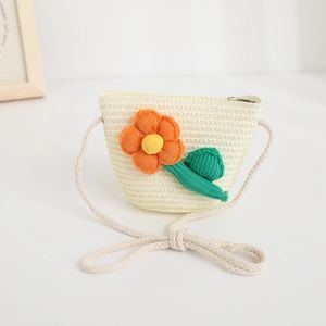 Detailed close-up of a cream woven straw crossbody bag featuring 3D knitted flower accents