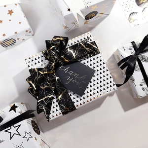 Premium black and gold gift wrapping set with starry paper ribbons and thank you tags