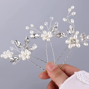 Detail view of 3-piece crystal hair pins with silver wire and pearls held by hand