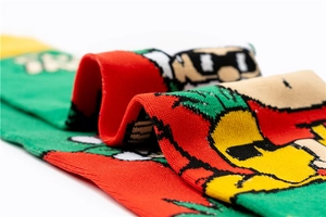 Close-up detail of knitted cotton Christmas socks with festive cartoon patterns and textures