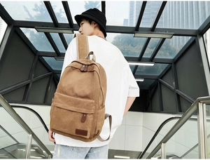 Brown canvas backpack featured in a modern urban lifestyle setting on an escalator