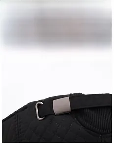 Détail de la boucle métallique et de la sangle réglable sur la casquette d'hiver noire