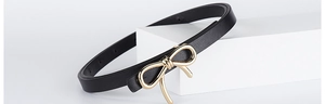Close-up of elegant black PU leather slim belt with a decorative golden bow buckle