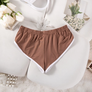 Detaillierte Flachbildansicht brauner Yoga-Shorts mit weißem Rand auf weißem Hintergrund