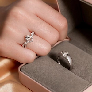 Detailed close-up of crown-themed couples rings with sparkling one-carat zircon stones