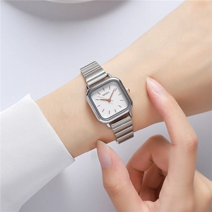 Modern square silver steel watch on wrist featuring white dial and rose gold markers