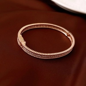 Macro shot of rose gold bangle with rows of white zircon and detailed beaded texture edges