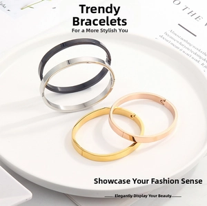 Detailed view of polished stainless steel bracelets in four colors on a ceramic dish