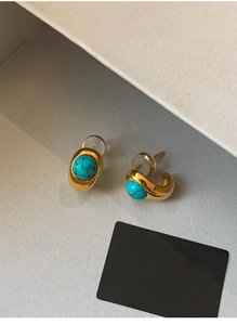 Macro view of 18k gold plated turquoise stud earrings featuring vintage metal texture