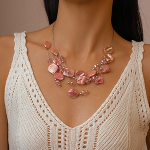Detail of layered multi-strand necklace with pink iridescent shells and silver beads
