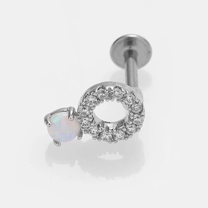 Détail macro du piercing labret en acier avec cercle en zircon et opale blanche sertie