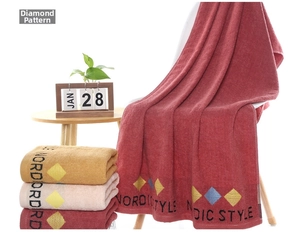 Detail showing plush cotton towels with Nordic style diamond embroidery and soft texture