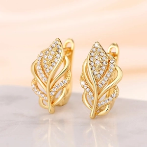 Macro shot of gold feather earrings encrusted with sparkling white zircon crystals