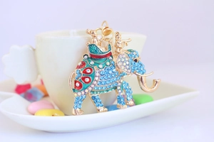Detail view of a golden elephant keychain with sparkling blue rhinestones and enamel accents