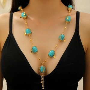 Bohemian gold chain necklace with turquoise stones and fringe tassels on a model