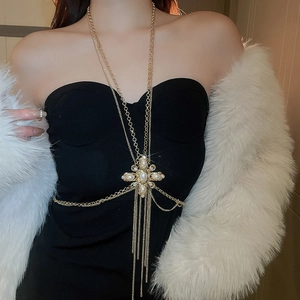 Detailed view of a gold body chain featuring a cross pendant with pearls and rhinestones