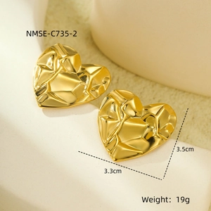 Detail view of gold heart earrings with textured finish and size measurements