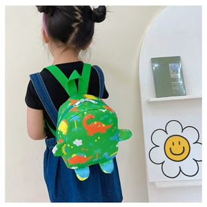 Detailed close-up of cartoon dinosaur pattern and 3D fin design on green kid's backpack