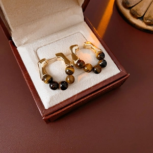 Macro shot of tiger eye bead earrings inside a premium jewelry gift box
