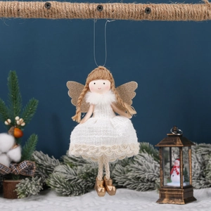 Ange de Noël avec robe en dentelle blanche et ailes dorées sur branche festive